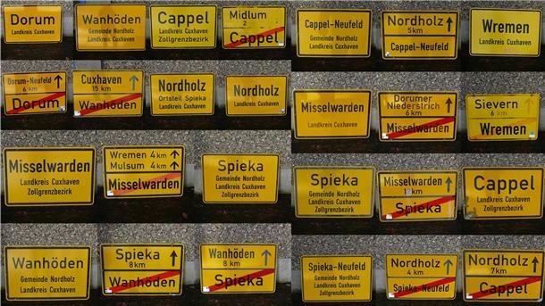 13 Ortstafeln (die Fotomontage zeigt Vor- und Rückseiten) aus der ehemaligen Samtgemeinde Land Wursten sowie der Gemeinde Nordholz.