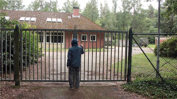 Ein Mann an einem Zaun mit Blick auf ein verlassenes Gebäude. 16 Meter unter der Erde: Tief im Grafeler Forst liegt der ehemalige Atombunker der Bundeswehr – einst Teil eines bundesweiten Kommunikationsnetzes für den Verteidigungsfall.