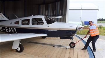 Markus Brandes, Vorsitzender des Aero Clubs Bremerhaven, zieht eine Schulungsmaschine aus dem Rundhangar des Flugplatzes Nordholz. 