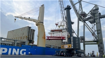 Ein Eisenbahnwagen wird im Braker Hafen von einem Schiff auf die Pier gehievt.