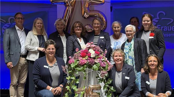 75 Jahre Landfrauen Wesermarsch: Feier auf der „Cap San Diego“ Mehrere Menschen stehen mit Blumen vor einer goldenen 75.