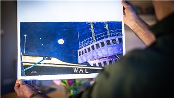 Achim Sauerland zeigt das von ihm gemalte Bild nach der Vorlage des Pressefotos vom Blutmond im Januar 2019 über dem Neuen Hafen und Dampfeisbrecher "Wal".