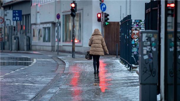 Winterwetter bremst Verkehr in Teilen Deutschlands aus Achtung, glatt: Eine Fußgängerin passiert in Saarbrücken einen Gehweg, der sich nach Blitzeis in eine Rutschbahn verwandelt hat.