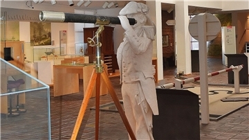 Eine weiße Skulptur eines historischen Admirals hält in den Ausstellungsräumen des Historischen Museums ein auf einem Stativ stehendes Fernrohr in der Hand.