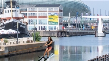 Fotomontage: Eine Frau fährt im Alten Hafen in Bremerhaven Wasserski.