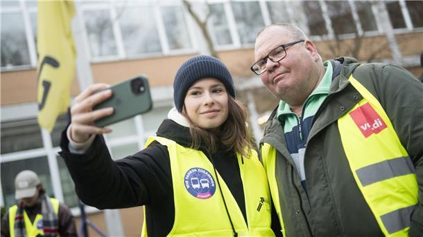Aktivistin Luisa Neubauer macht am BVG–Busdepot Cicerostraße in Berlin mit Streikleiter Lothar ein Selfie.