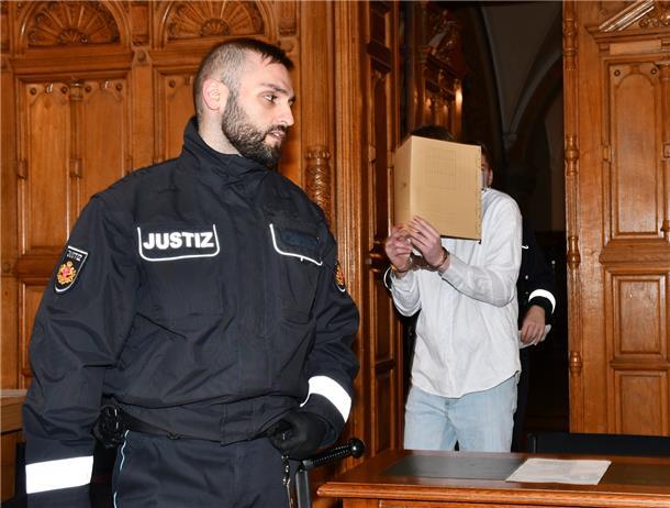 Angeklagter mit Justizbeamten im Gerichtssaal 