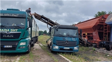 Zwei Lkw stehen bei einem Güterzug. Am Bahnhof Selsingen wurde Mineraldünger mithilfe eines mobilen Förderbands direkt aus den Waggons entladen. Innerhalb weniger Minuten gelangte die Fracht auf die bereitgestellten LKW.