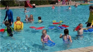 Kleine Kinder vergnügen sich im Wasser. 