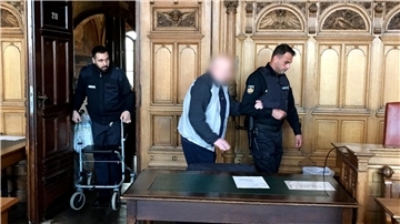 Zwei Justizbeamte führen den Angeklagten in den Gerichtssaal.