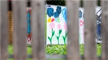 Am Rand einer Brachfläche hängen von Kindern gestaltete Plakate an Bauzäunen. An dieser Stelle stand das Haus, vor dem der Messerangriff auf zwei Schülerinnen stattfand.