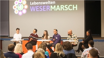 Gruppe von Menschen bei einer Podiumsdiskussion