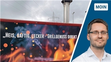 Eine Grillbude, auf der geschrieben steht: "Heis, saftig, lecker - Grillgenuss direkt". Im Bild nicht zu sehen ist, dass der Satz noch weitergeht. Da heißt es: "Auf die Hand". Der Wagen hat ein Flammen-Design.