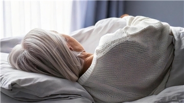 Kampf mit Trauer und Krankheit: Leidgeplagte Bremerhavenerin bekommt Hilfe Eine Seniorin mit grauen Haaren liegt auf einem Bett.