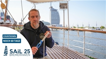 Ein Mann sitzt in Bremerhaven an Bord der „Schulschiff Deutschland“ und erklärt den Schotstek – einen Seemannsknoten.