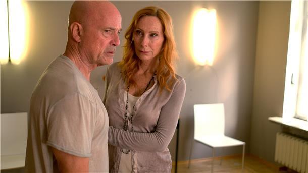 Andreas (Christian Berkel) steht pitschnass mit Ulrike (Andrea Sawatzki) am Sarg ihres Vaters.