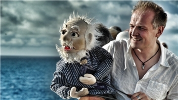 Ein Mann und eine Handpuppe in Form eines Kapitäns.