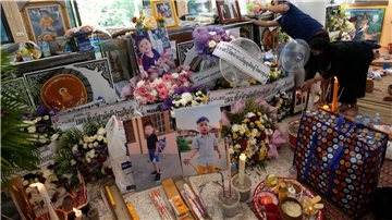 Angehörige der Opfer des Kita-Attentats sammeln Bilder und Andenken vor einer buddhistischen Zeremonie in der Stadt Uthai Sawan im Nordosten Thailands.