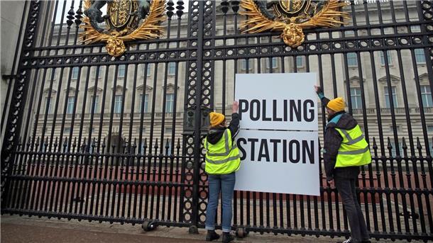 Teure Krönung von König Charles in der Kritik Anhänger der Kampagnengruppe Republic hängen ein Wahllokalschild ans Geländer des Buckingham Palace in London.