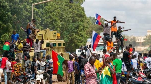 Nach Putsch in Burkina Faso: Gestürzter Präsident gibt auf Anhänger von Hauptmann Traore jubeln mit russischen Fahnen in den Straßen von Burkina Fasos Hauptstadt Ouagadoudou.