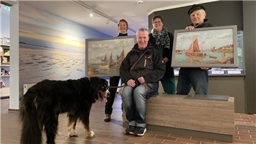 Anika Seyfferth, Martina Geberzahn und Harry Thaden (hinten, von links) präsentieren die beiden Wilke-Bilder, für die Thomas Schwingel von der Manufaktur Andreaswerk die Rahmen ausgewählt hat. Hündin Mieke vertritt den Spender, der anonym bleiben möchte.