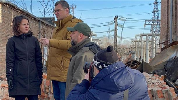 Annalena Baerbock im Gespräch mit dem ukrainischen Außenminister Dmytro Kuleba (3.v.r) in Charkiw auf dem Gelände eines den Russen zerstörten Umspannwerkes.