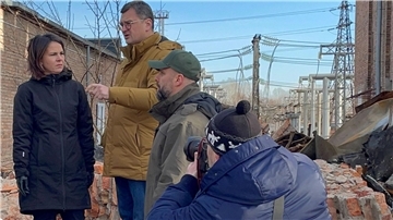 Annalena Baerbock im Gespräch mit dem ukrainischen Außenminister Dmytro Kuleba (3.v.r) in Charkiw auf dem Gelände eines den Russen zerstörten Umspannwerkes.