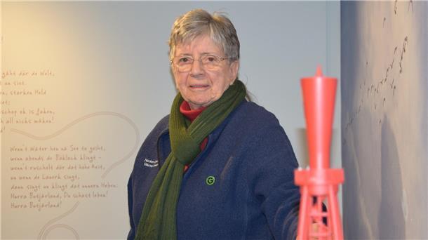 Annegret Martens steht vor einem Leuchtfeuer-Modell im Nationalparkhaus Museum Fedderwardersiel. 