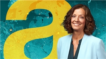 Antje Pieper steht vor einer digitalen Weltkarte im Studio dews „auslandjournals“.