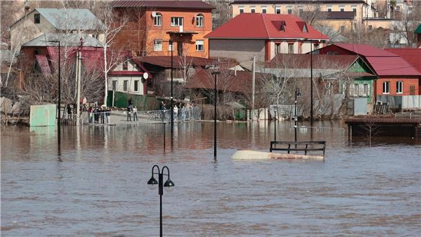 Hochwasserlage in Russland bleibt angespannt Anwohner stehen an einer Absperrung und beobachten ein überschwemmtes Gebiet im russischen Orenburg.