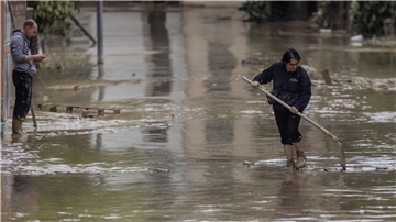 Anwohner versuchen nach Überschwemmungen eine Straße in Faenza von Schlamm und Wasser zu befreien.