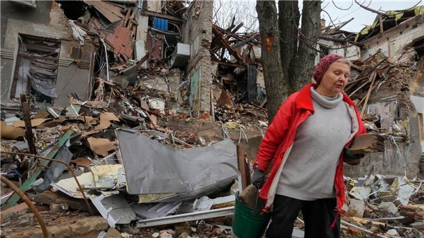 Krieg gegen die Ukraine: So ist die Lage Anwohnerin Nina (72) trägt in Slowjansk hölzerne Trümmer in der Nähe ihres Hauses, das durch Beschuss vor einem Monat zerstört wurde.