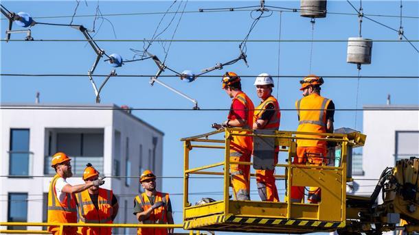 Erste Gleise freigegeben: Zugverkehr in München rollt wieder Arbeiter reparieren in München eine abgerissene Oberleitung.