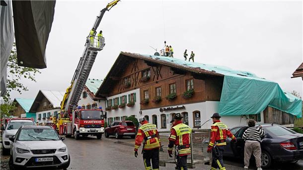 Entspannung in Hochwasser-Gebieten in Bayern und Österreich Arbeiter und Feuerwehrleute beseitigen die Unwetter-Schäden im oberbayerischen Bad Bayersoien. Bei dem Unwetter wurden viele Dächer beschädigt.