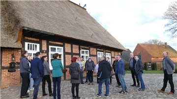 Mehrere Menschen stehen vor dem  Niedersachsenhaus in Bramstedt. 