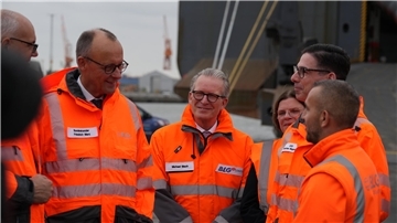 Hier gibt’s alle Bilder vom Besuch von Kanzler Merz in Bremerhaven Bundeskanzler Friedrich Merz spricht im Bremerhavener Hafen mit einem Mitarbeiter.