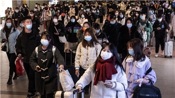  Passagiere kommen am Bahnhof Hankou an und tragen Mund-Nasen-Schutz. 