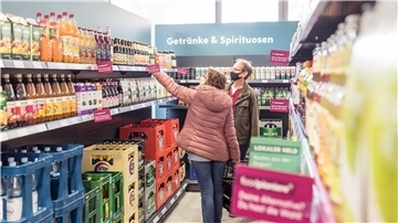 Menschen kaufen in einem Tante-Enso-Laden ein.