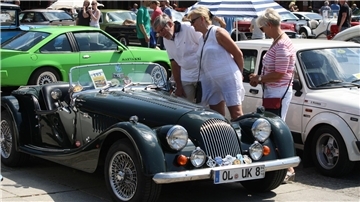 Menschen gucken sich Oldtimer an