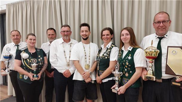 Männer und Frauen haben sich zum Gruppenbild aufgestellt.