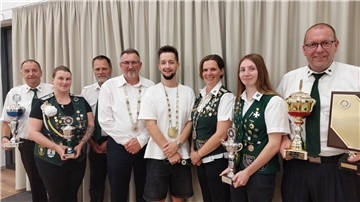 Männer und Frauen haben sich zum Gruppenbild aufgestellt.