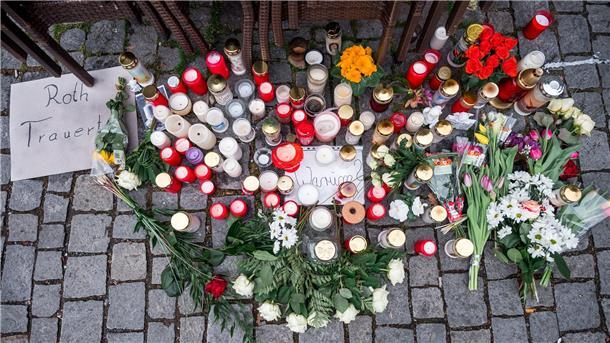 Auf dem Platz vor dem Blumengeschäft sind Blumen und Kerzen als Zeichen der Trauer niedergelegt.