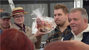 Der Sammler Marijano Weimar hält den Schweinskopf in der Hand und geht durch das Festzelt.