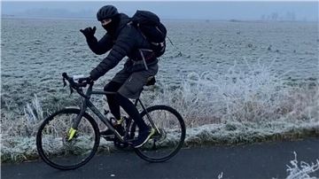 Junger Radfahrer vor einer Wiese mit Bodenfrost