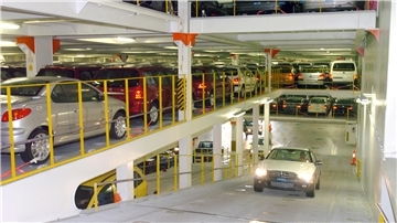 Ein Auto fährt auf einer Rampe zwischen den Ladedecks eines Autotransporters