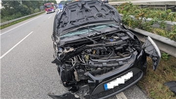 ein zerstörtes Auto steht nach einem Unfall auf einer Autobahn 