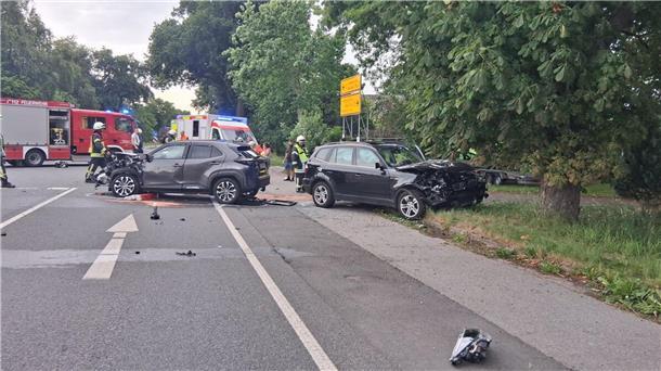 Schwerer B73-Unfall bei Wingst: Straße stundenlang gesperrt Zwei verunfallte Autos stehen auf einer Straße. Im Hintergrund sind Fahrzeuge der Feuerwehr.