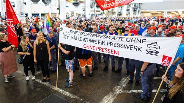 Auf der Betriebsversammlung in Wolfsburg begrüßen Mitarbeiter den Vorstand mit scharfem Protest gegen die jüngsten Sparpläne.