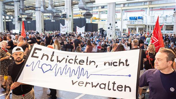 Auf der Betriebsversammlung in Wolfsburg begrüßen Mitarbeiter den Vorstand mit scharfem Protest gegen die jüngsten Sparpläne.