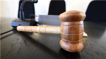 Auf der Richterbank liegt ein Richterhammer aus Holz.